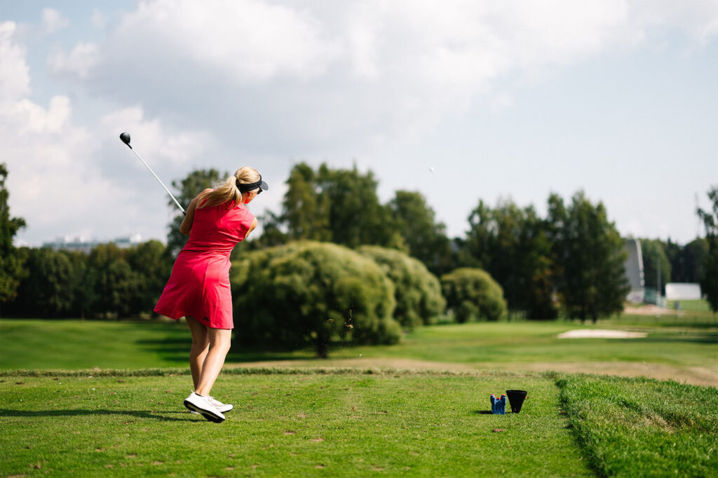 Nainen lyö avauksen par 3 -reiällä.